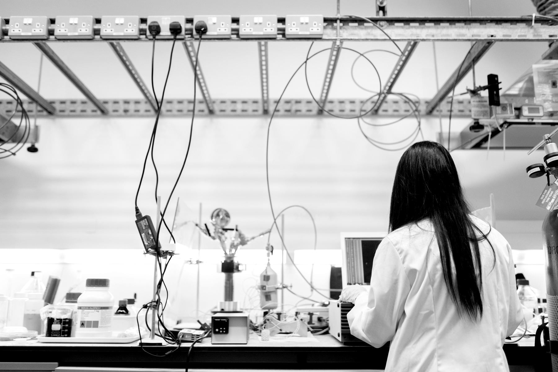 A researcher working at a laboratory bench with optical and electronic equipment